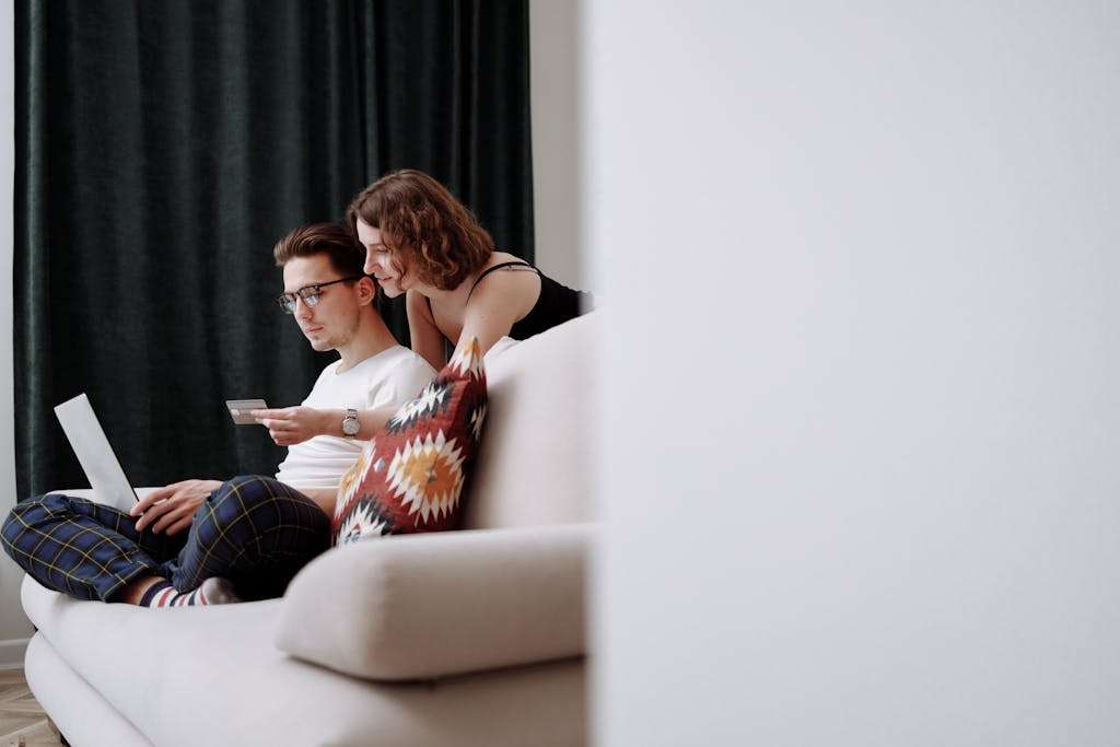 Woman Holding a Credit Card in Front of a Man