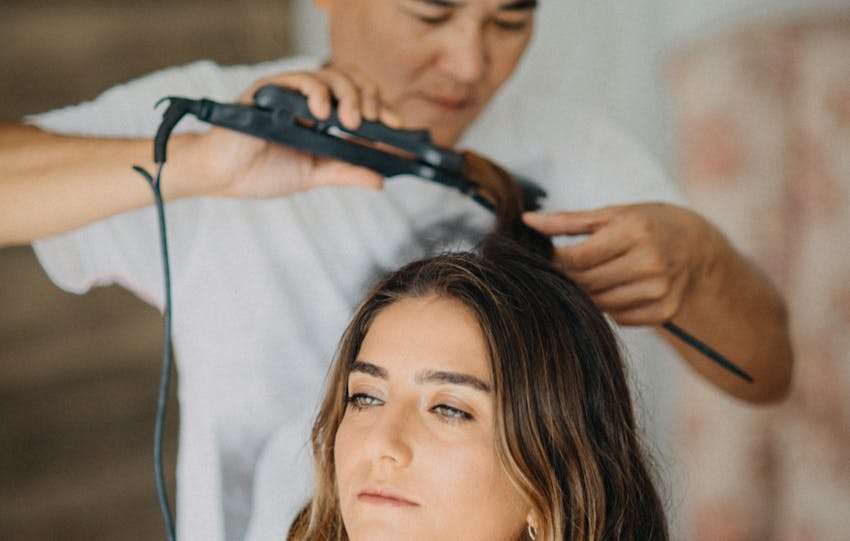 haar van een vrouw word gestijlt met een stijltang