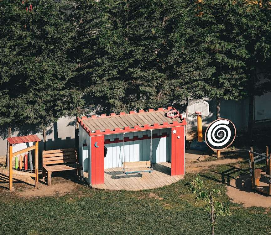 rood tuinhuisje met schommel