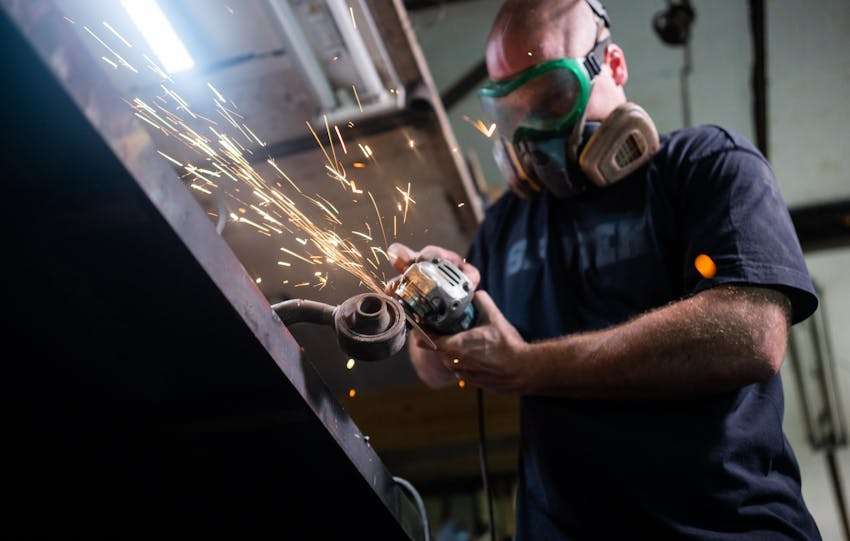 man aan het werk met en haakse slijper