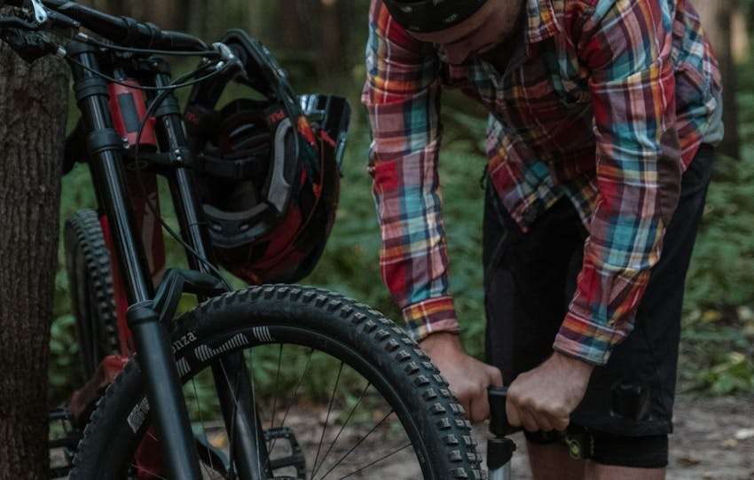 man pompt fietsband op met een fietspomp