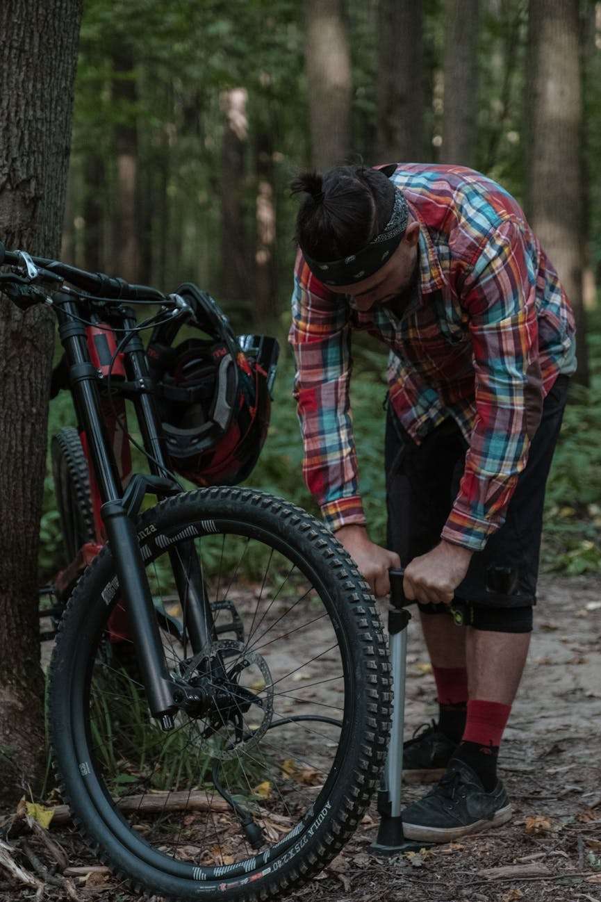 man pompt fietsband op met een fietspomp