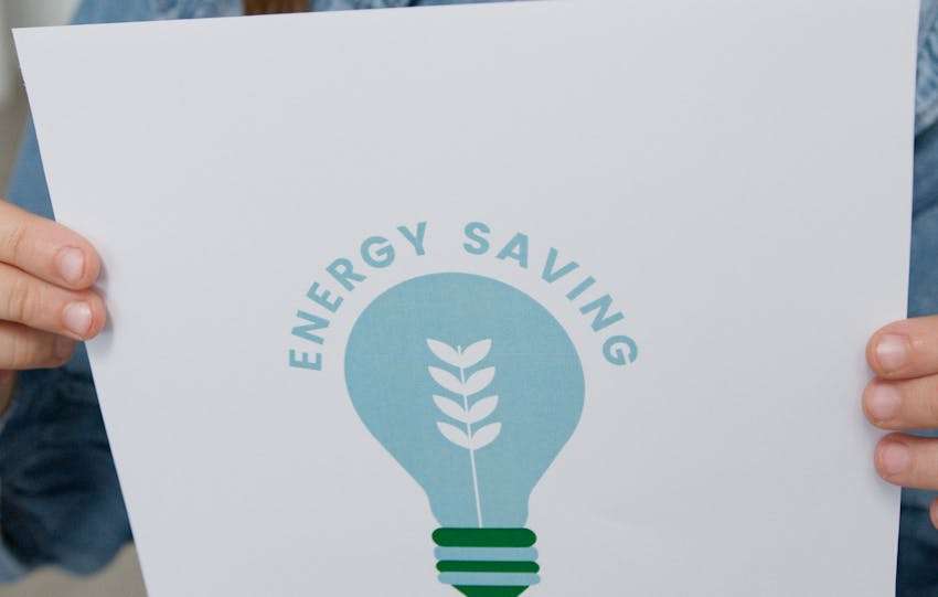 meisje die een afbeelding vast houdt waarop staat "saving energy"