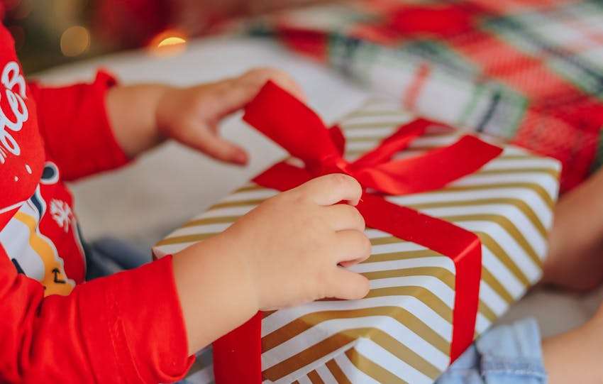 kind die een kerstcadeau gaat uitpakken