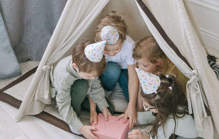 kinderen in een tent die cadeau openmaken