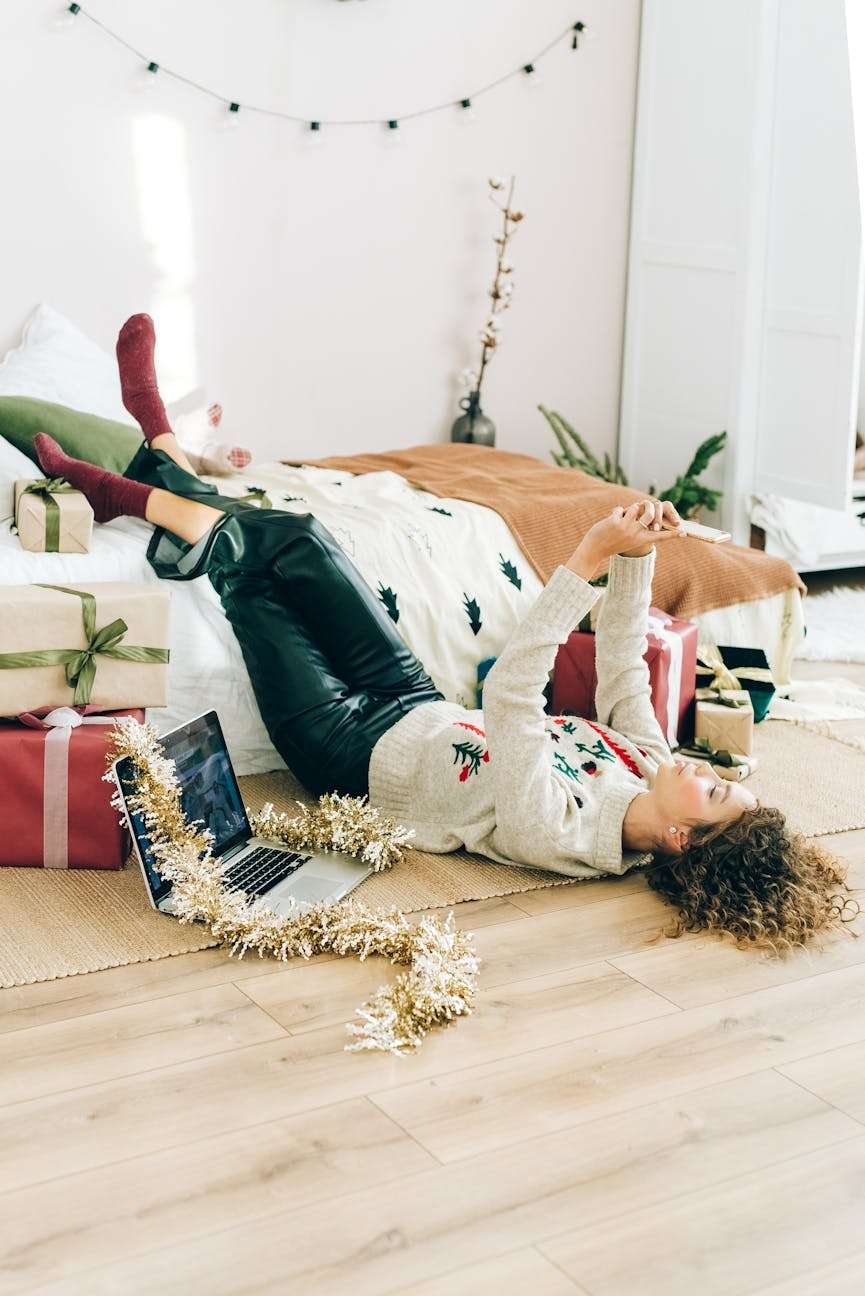 vrouw die op de grond ligt omringd door cadeaus