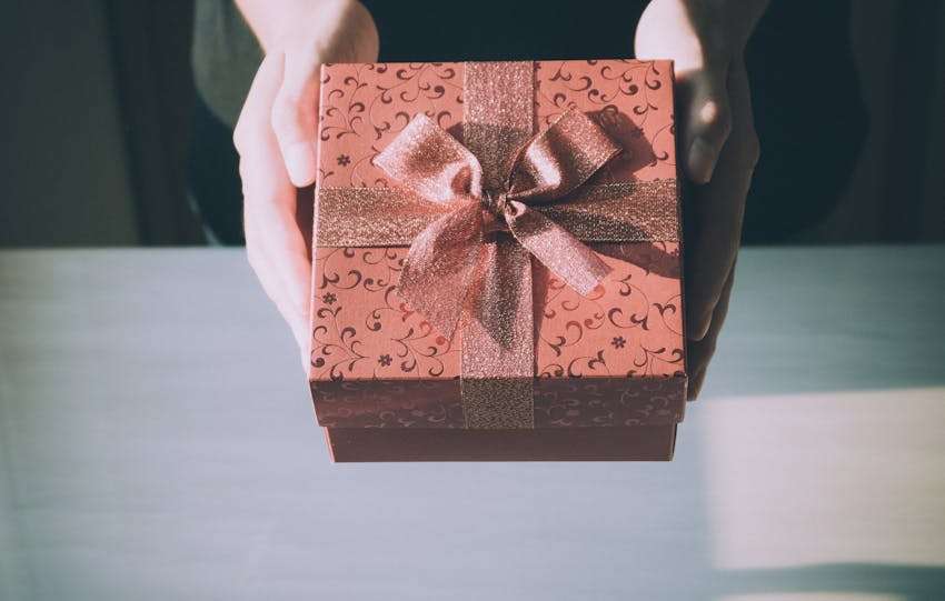 iemand die een roze cadeau geeft