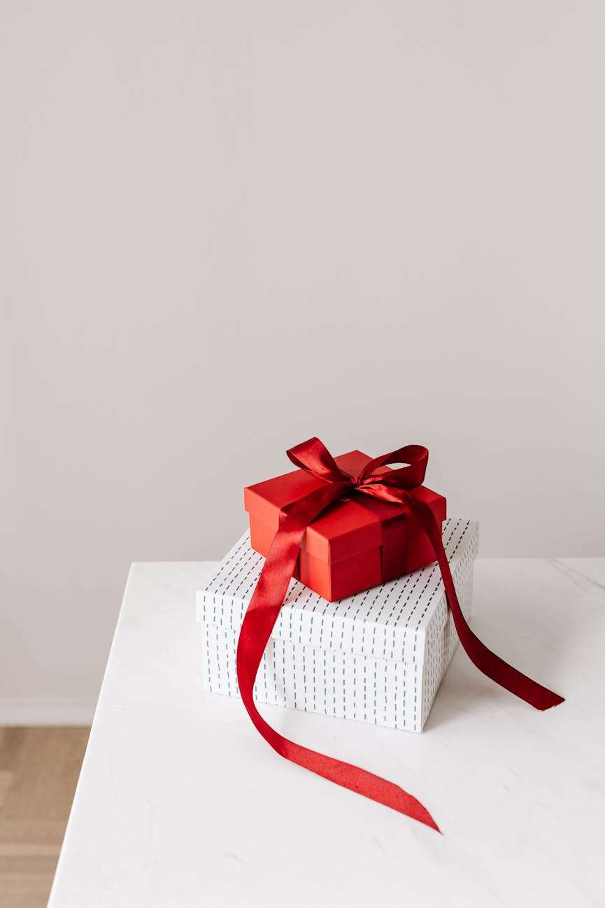 rood cadeau bovenop een witte doos